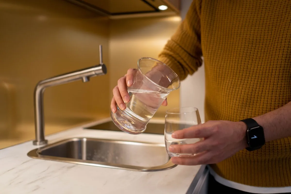 A refreshing glass of clear, filtered water at a bright modern Houston kitchen sink